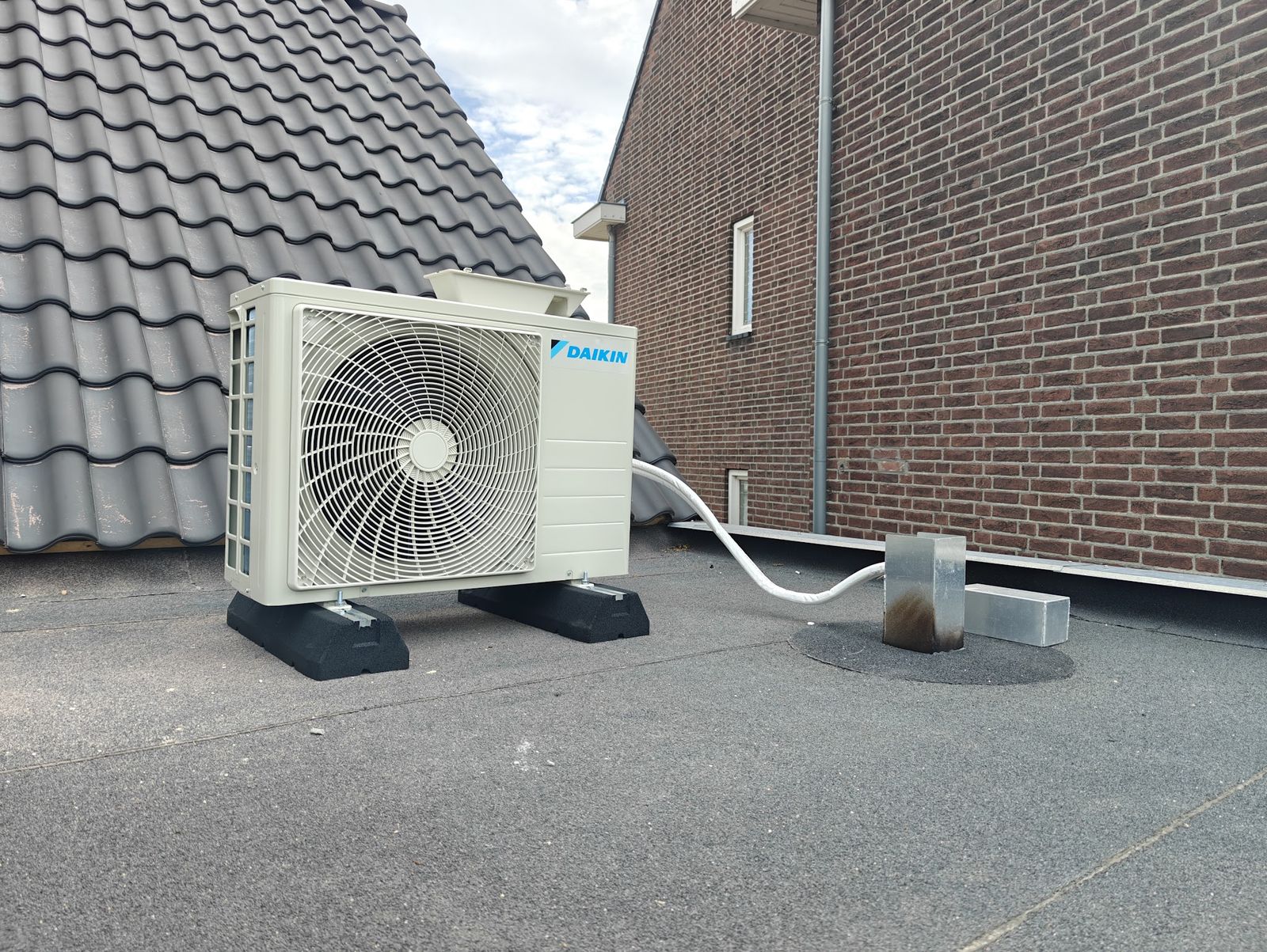 Daikin-buitenunit op rubberen voeten op een plat dak, geplaatst door KT Airco's And More
