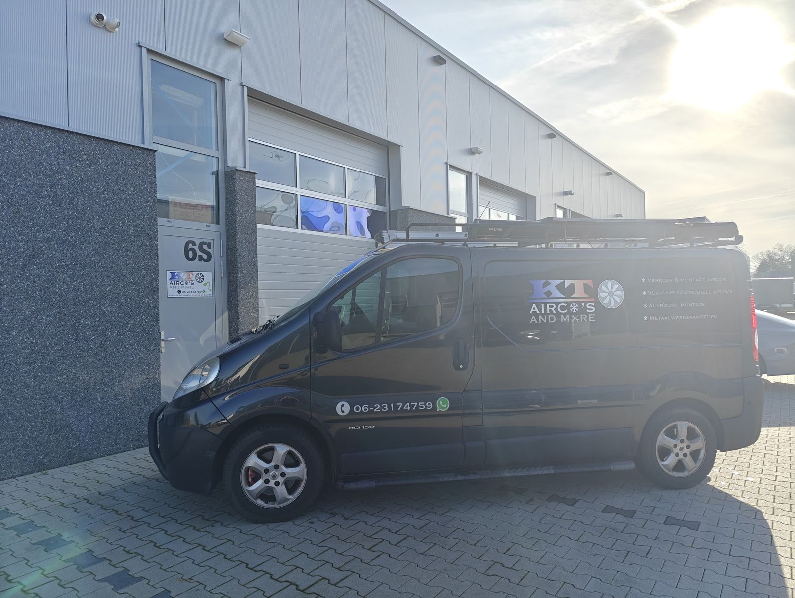 De zwarte bus van KT Airco's And More met logo en telefoonnummer, voor bedrijfsunit 6S aan De Hoefkens in Helmond